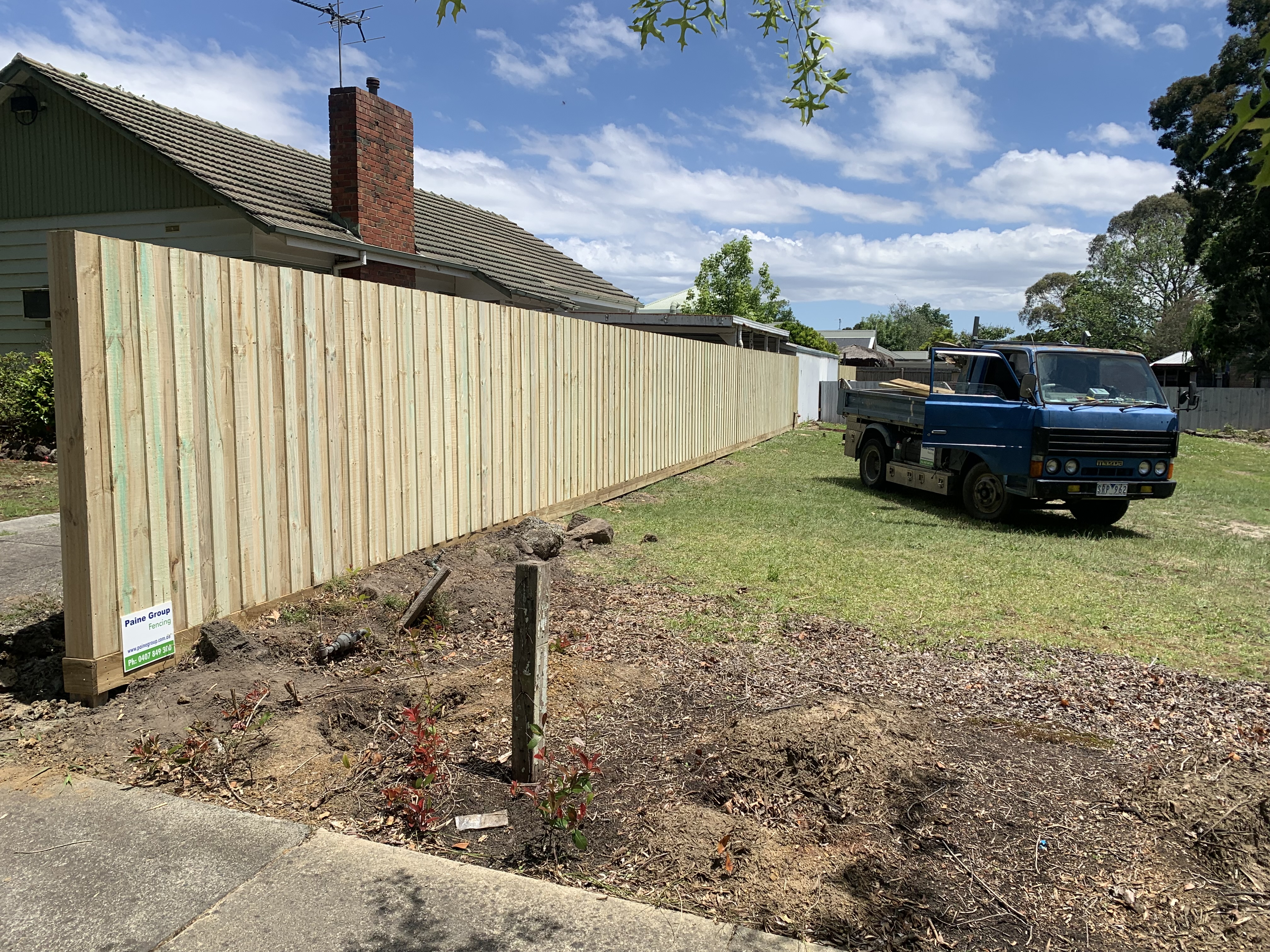 Long timber paling fence installation